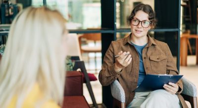 A female psychologist advises a client. Portrait of a professional modern woman. HR hires and conducts interviews.